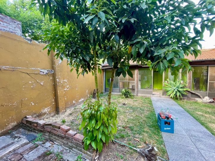 Casa de 6 ambientes en lote de 8.66x30, con cochera cubierta, quincho y jardin